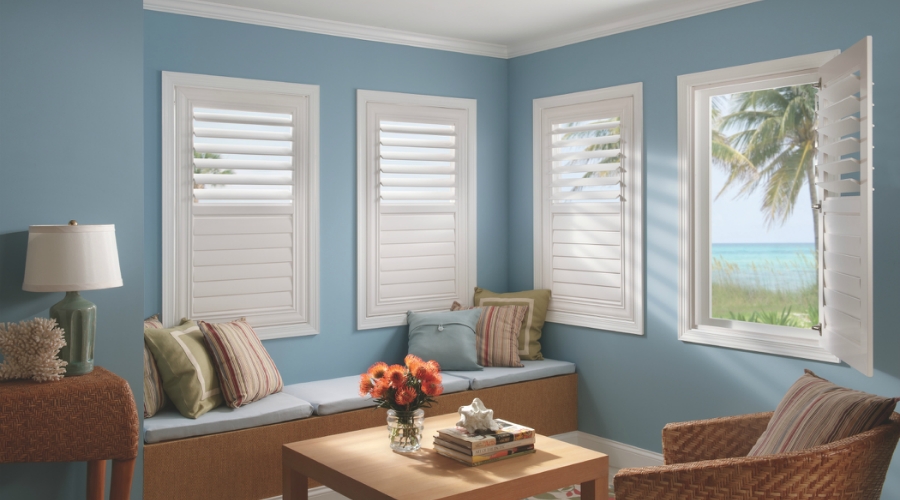 In this beautiful image, these shutters feature a picture frame design, an ornate panel edge, a decorative divider rail, and a hidden tilt.  ShutterLuxe can add the finishing touches to any room!